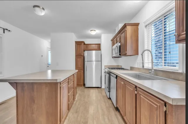 a kitchen with stainless steel appliances granite countertop a sink stove and refrigerator