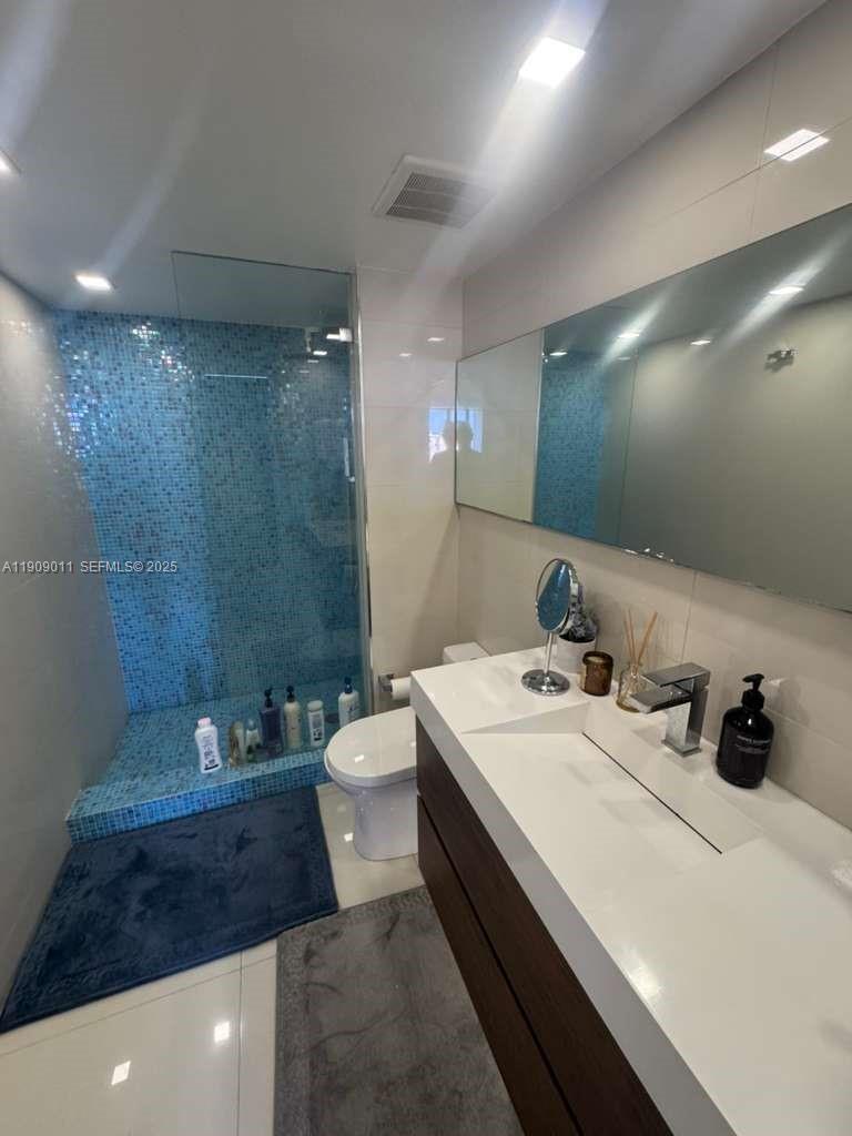4000 Towerside Terrace, Unit 1901 Miami, FL 33138 - Photo 35 of 36 a bathroom with a double vanity sink toilet and a mirror