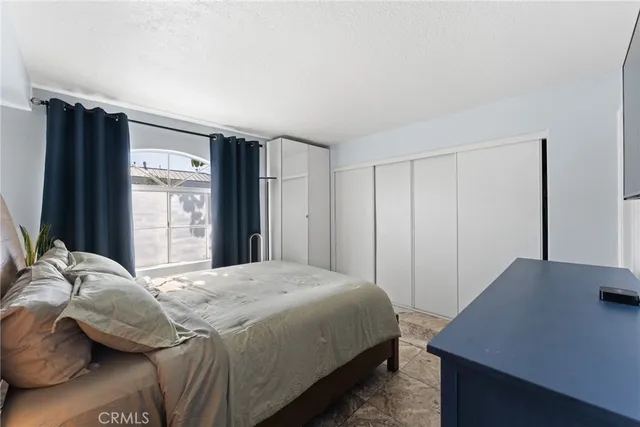 a bedroom with a bed and a flat screen tv