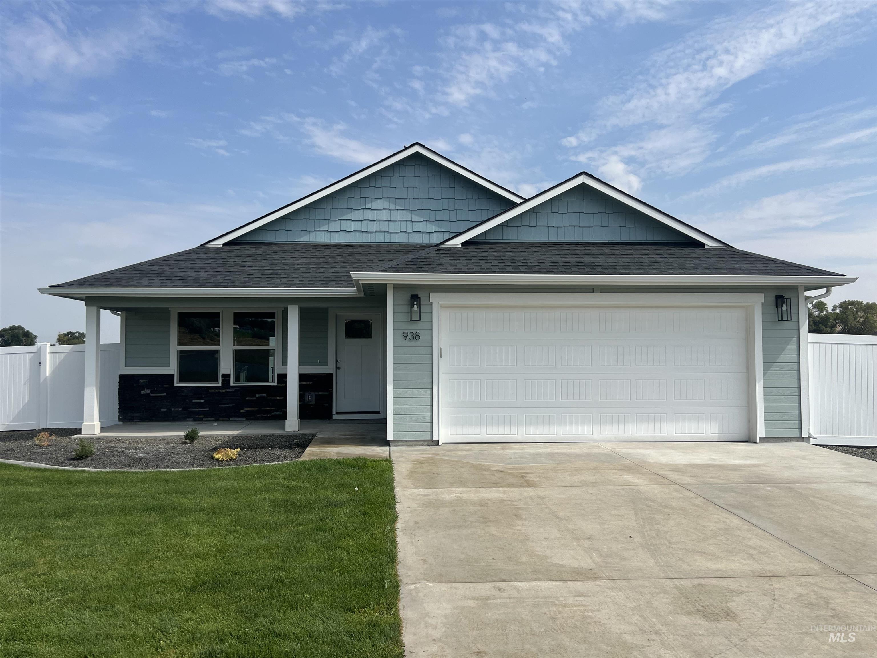 View of front of home featuring a shingled roof, covered porch, driveway, and a garage