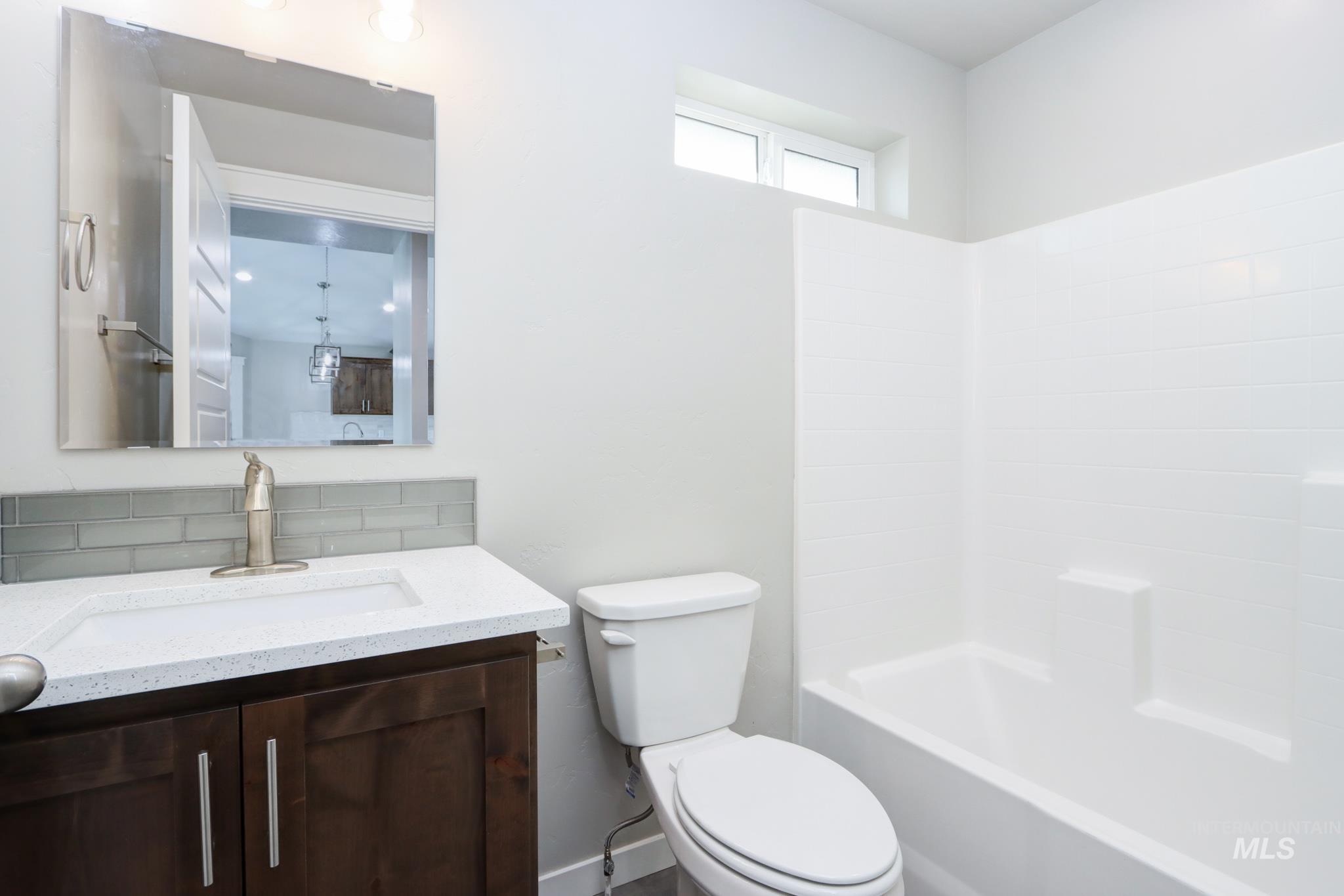 824 North 5th Street Nyssa, OR 97913 - Photo 19 of 23 Full bathroom featuring vanity, shower / tub combination, and backsplash