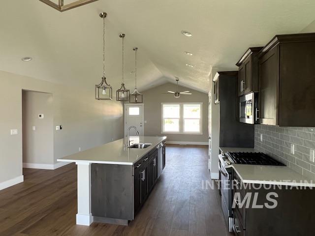 824 North 5th Street Nyssa, OR 97913 - Photo 4 of 23 Kitchen with stainless steel appliances, lofted ceiling, a kitchen island with sink, decorative light fixtures, and dark wood-style floors