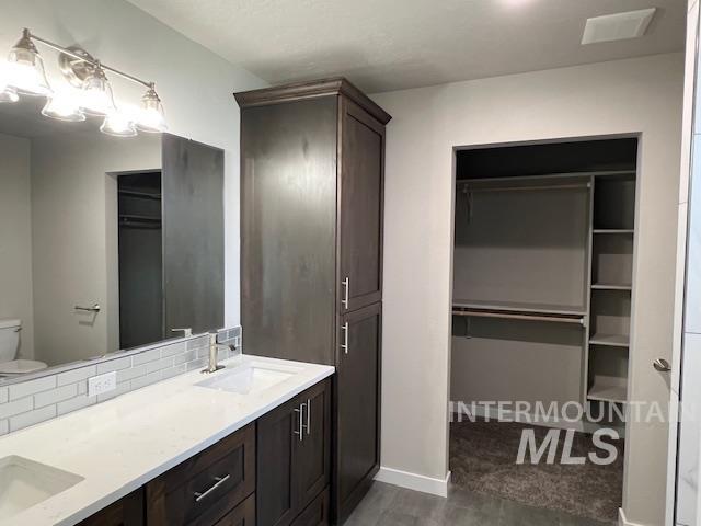 824 North 5th Street Nyssa, OR 97913 - Photo 6 of 23 Full bathroom with a walk in closet, double vanity, and decorative backsplash