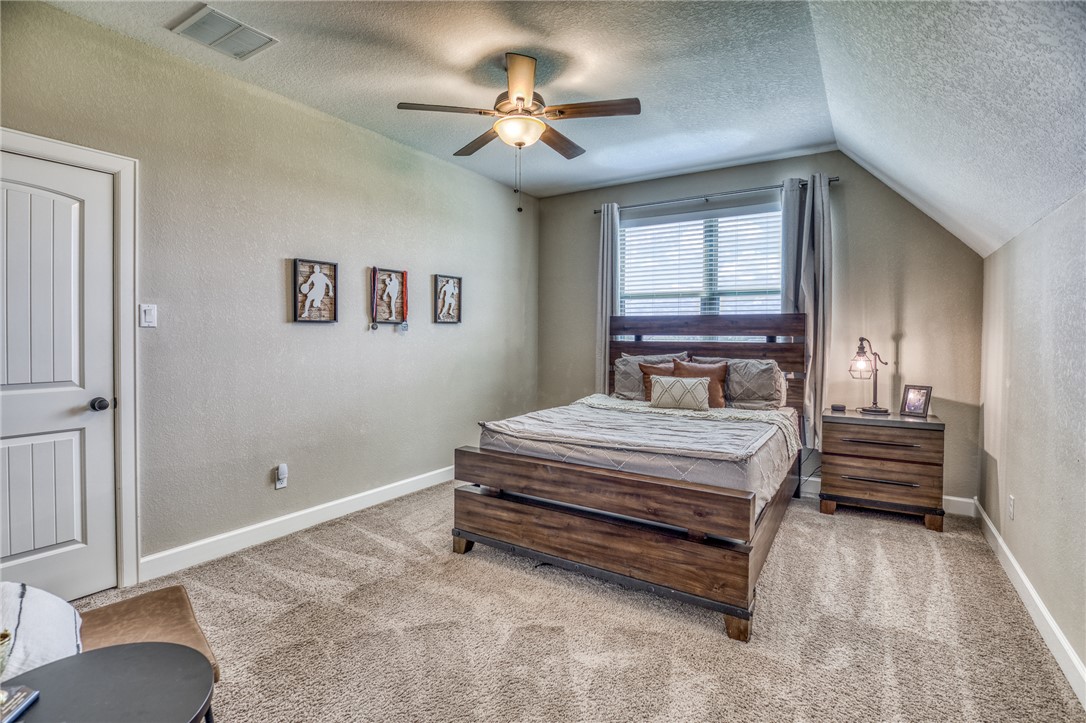 586 Ruby Drive Bellville, TX 77418 - Photo 25 of 50 a bedroom with a bed and a chandelier