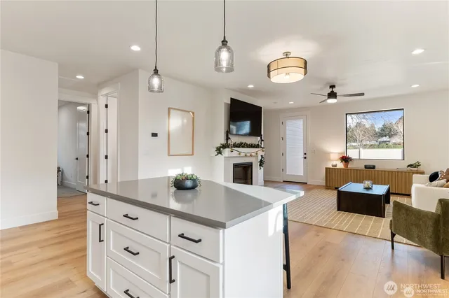 a large kitchen with stainless steel appliances a stove center island a stove and a window