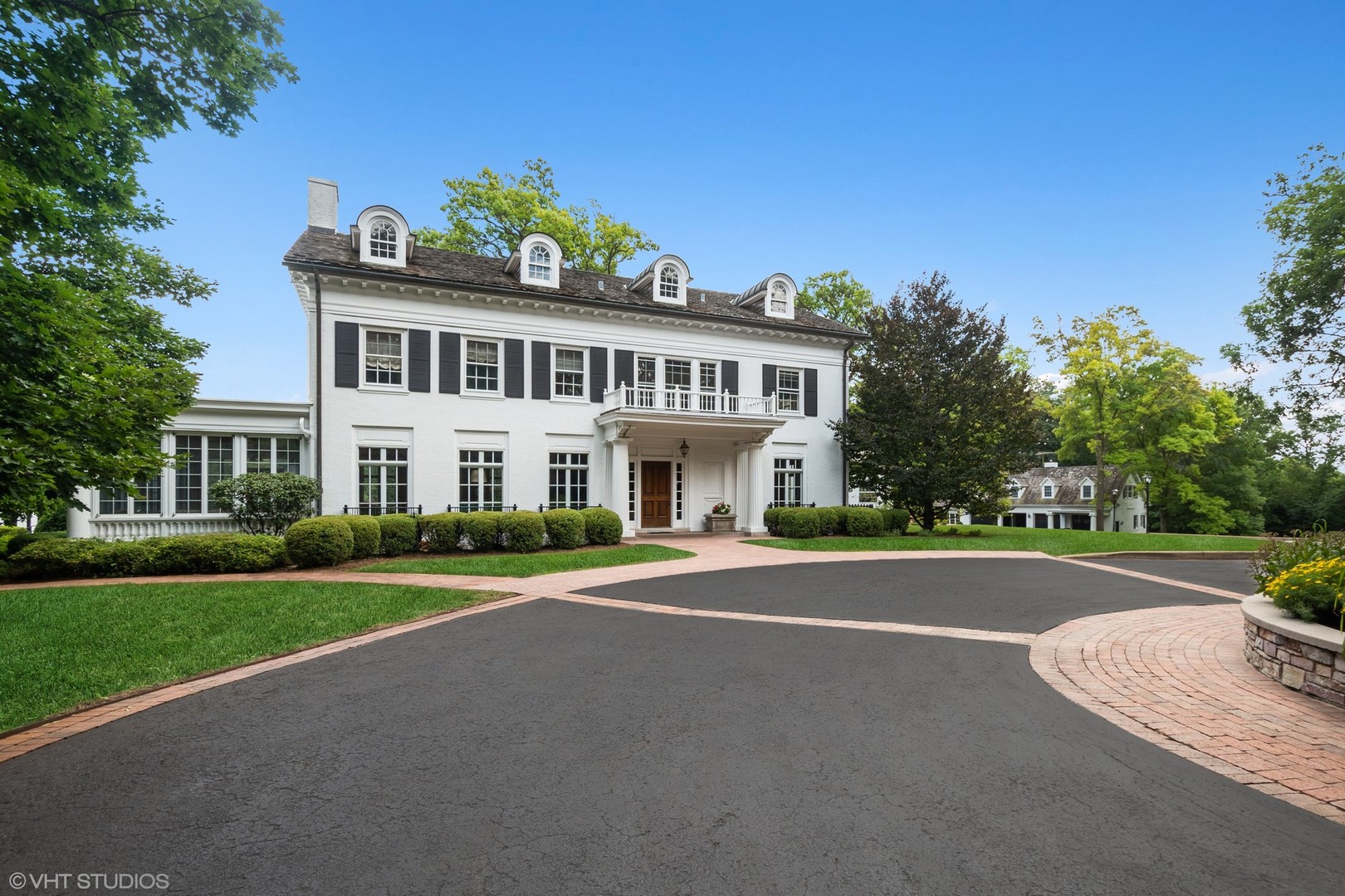 5 West County Line Road Barrington Hills, IL 60010 - Photo 6 of 77 a view of a white house with a big yard and potted plants