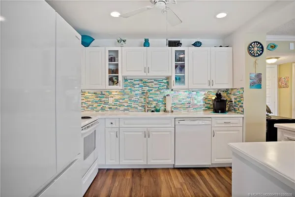 a kitchen with granite countertop white cabinets and white appliances