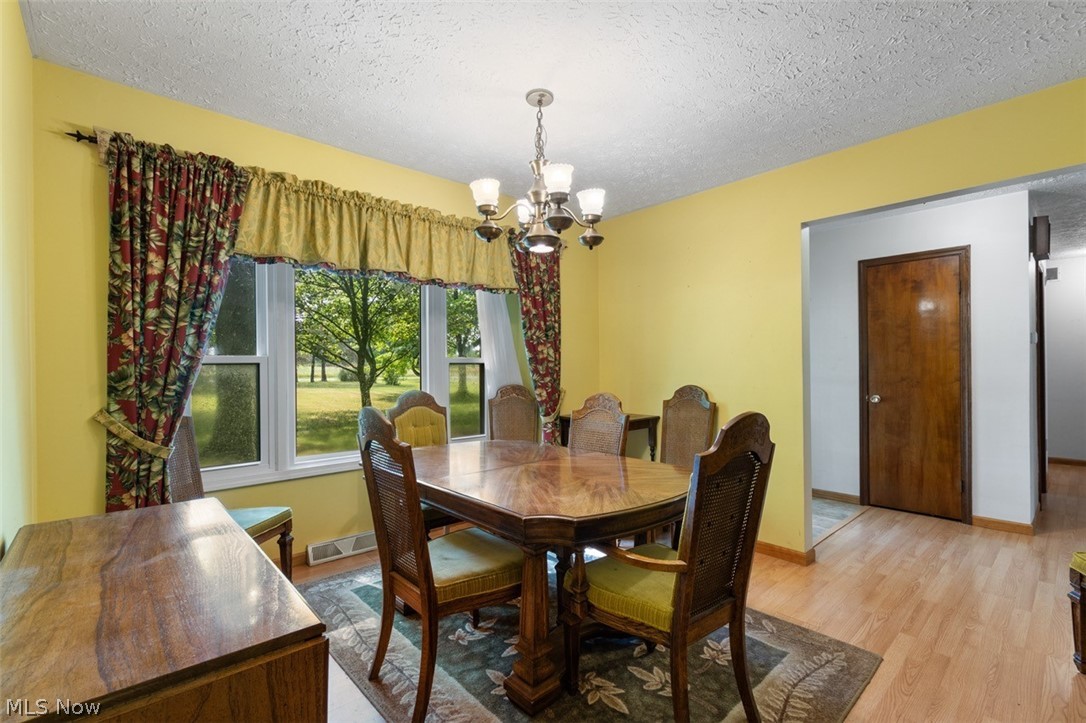Acme Road Rittman, OH 44270 - Photo 26 of 45 Dining room featuring a chandelier, a textured ceiling, and light hardwood / wood-style flooring