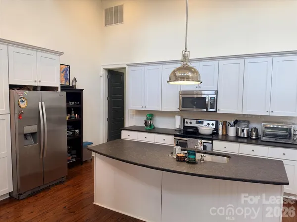 a kitchen with stainless steel appliances granite countertop a sink refrigerator and cabinets