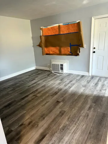 a view of empty room with wooden floor