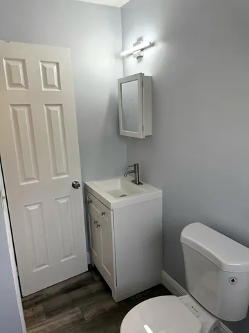 a bathroom with a toilet sink and mirror