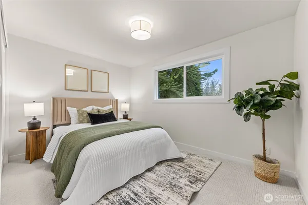 a bedroom with a bed and a potted plant
