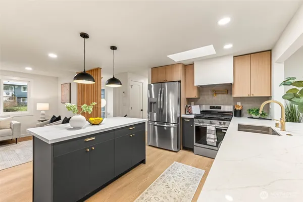 a kitchen with a sink a counter top space stainless steel appliances and cabinets