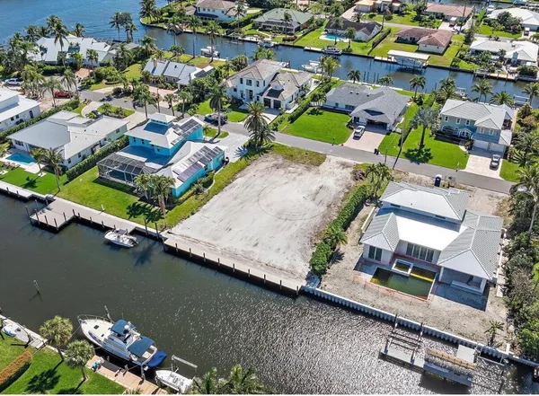 an aerial view of a house with a yard and lake view