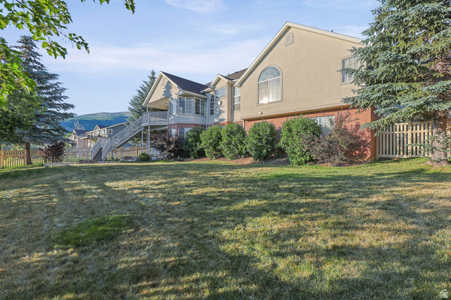 4117 North Wolf Ridge Circle Eden, UT 84310 - Photo 49 of 63 Expansive rear lawn featuring mature evergreen trees and a wood picket fence
