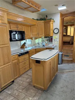 a kitchen with stainless steel appliances granite countertop a sink and a refrigerator