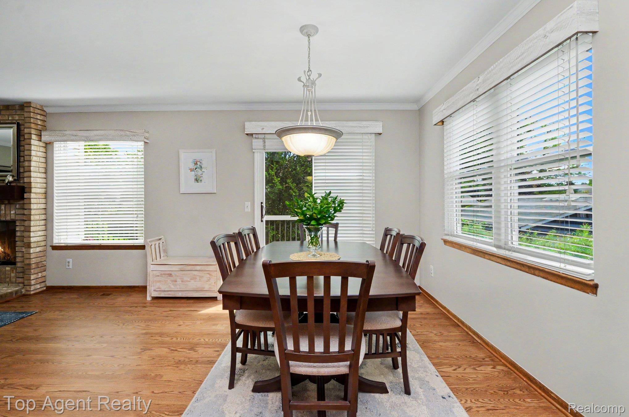 3759 Donley Avenue Rochester, MI 48309 - Photo 8 of 29 Spacious dining area featuring wood-finish flooring, a brick fireplace with a wood mantel, crown molding, and large windows with blinds