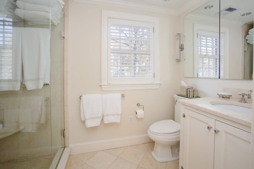 97 Laurel Road Brookline, MA 02467 - Photo 20 of 33 a bathroom with a toilet a sink a mirror and a window