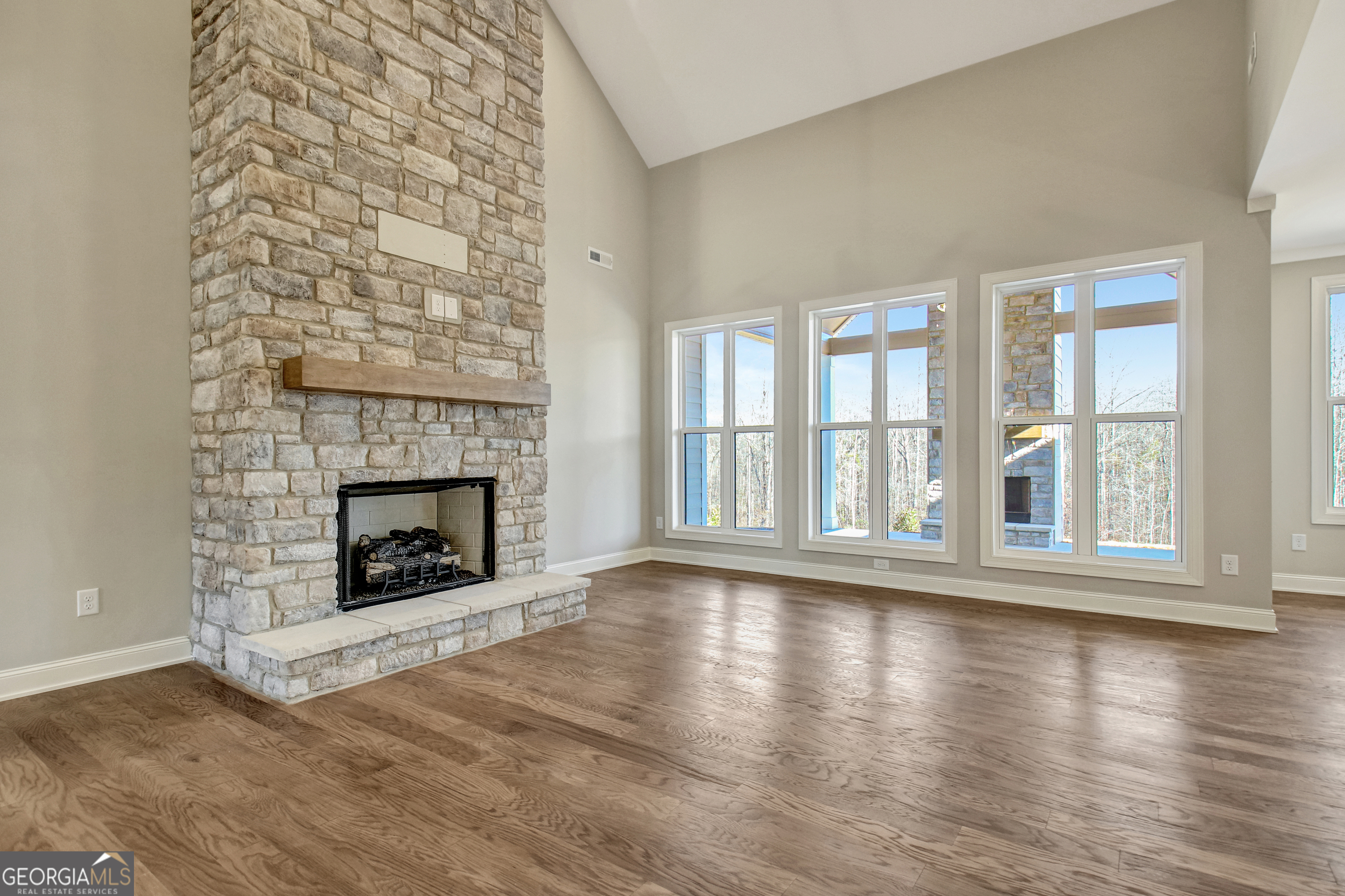 355 Werner Way Senoia, GA 30276 - Photo 19 of 118 wooden floor fireplace and windows in an empty room