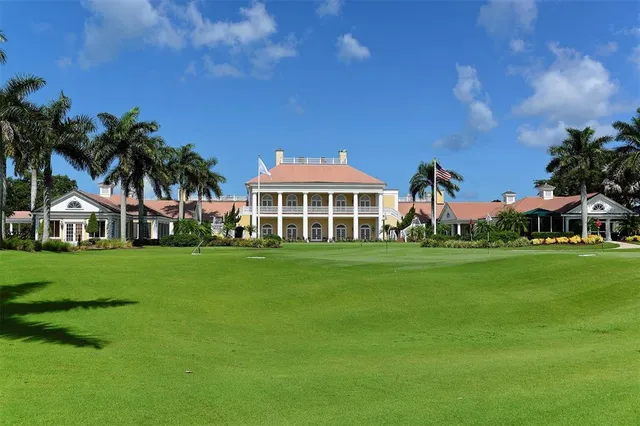 a front view of a house with a yard and palm trees