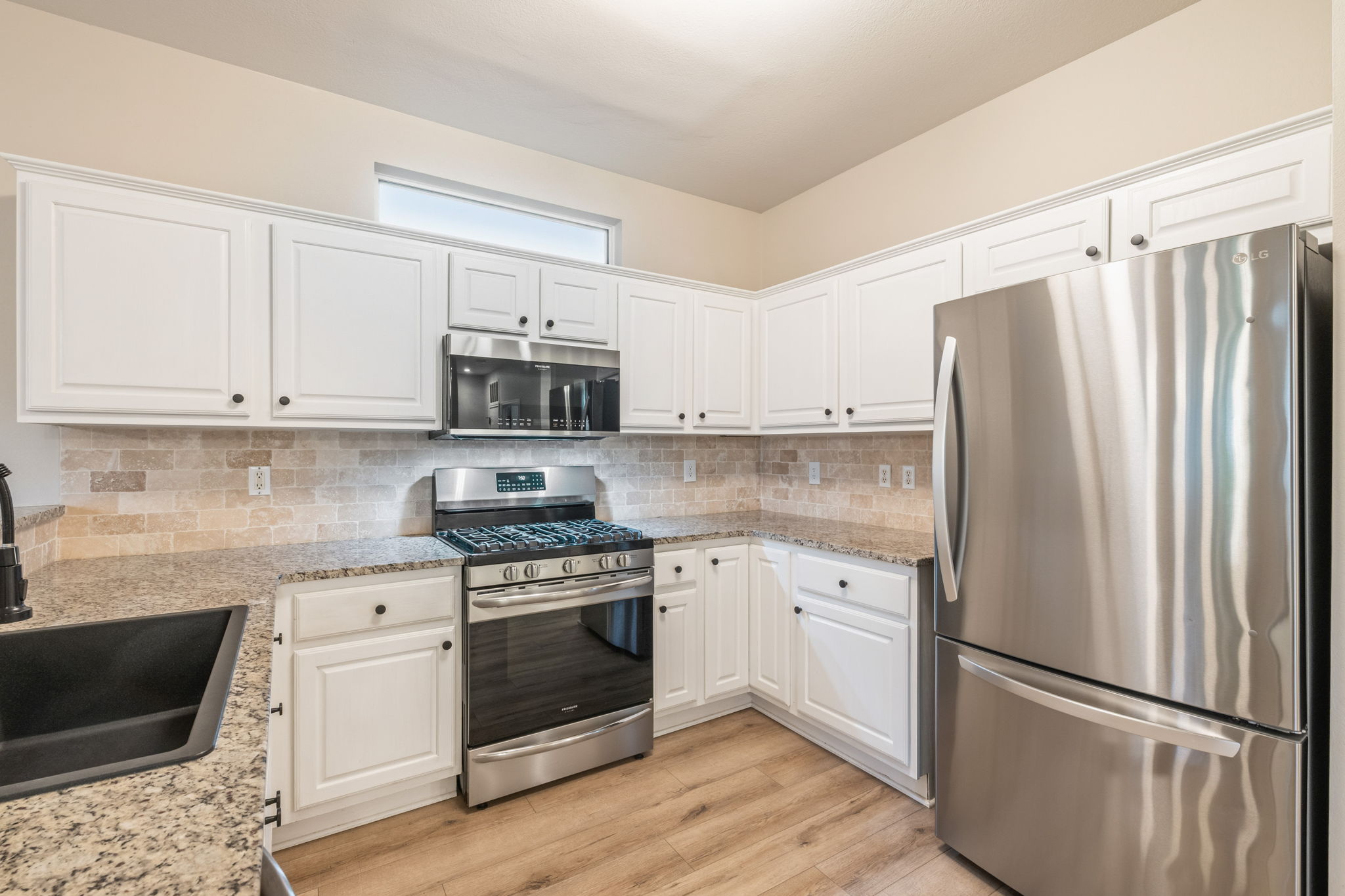 137 Trail Rider Way Georgetown, TX 78633 - Photo 7 of 29 Culinary dreams come alive in this kitchen featuring abundant white cabinetry and sleek stainless steel appliances.