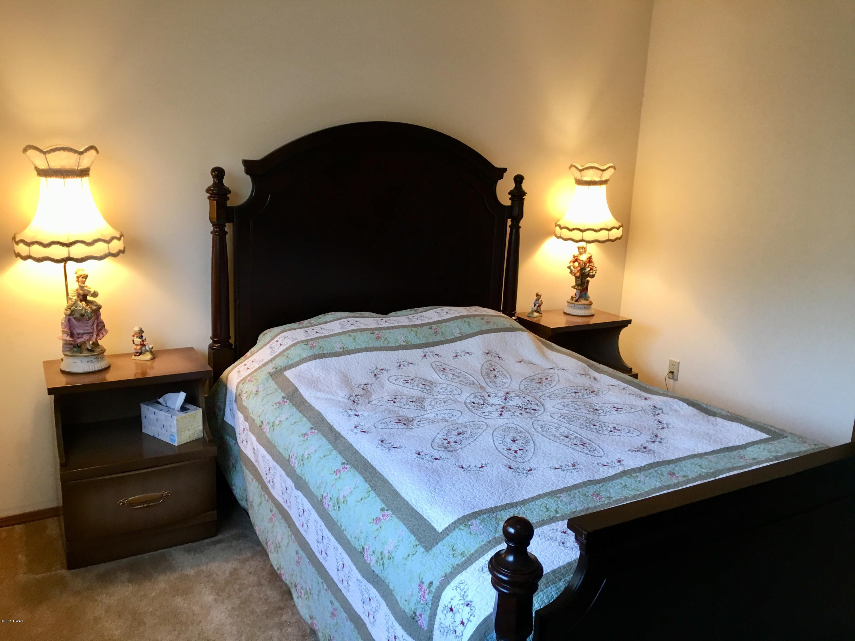 2375 Crest View Road Lake Ariel, PA 18436 - Photo 26 of 30 a bed sitting in a bedroom next to a lamp