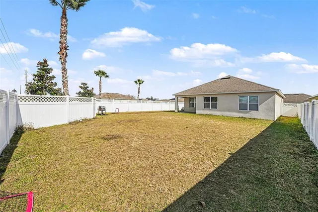 a view of an house with backyard and swimming pool