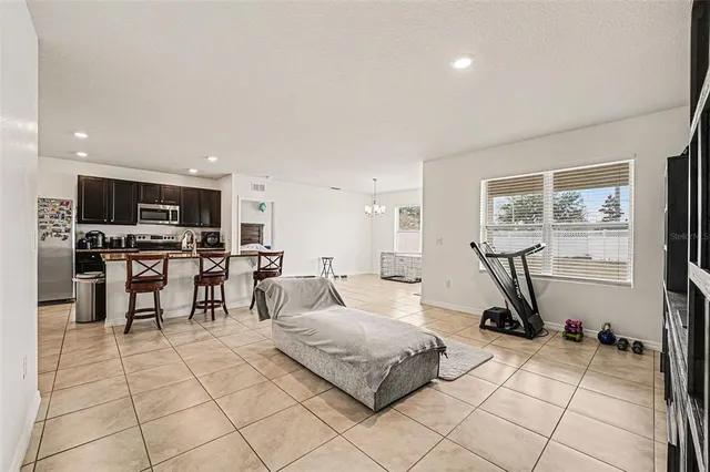 a living room with furniture a flat screen tv and kitchen view