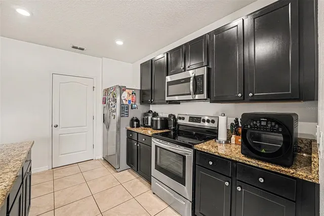 a kitchen with stainless steel appliances granite countertop a stove and a refrigerator