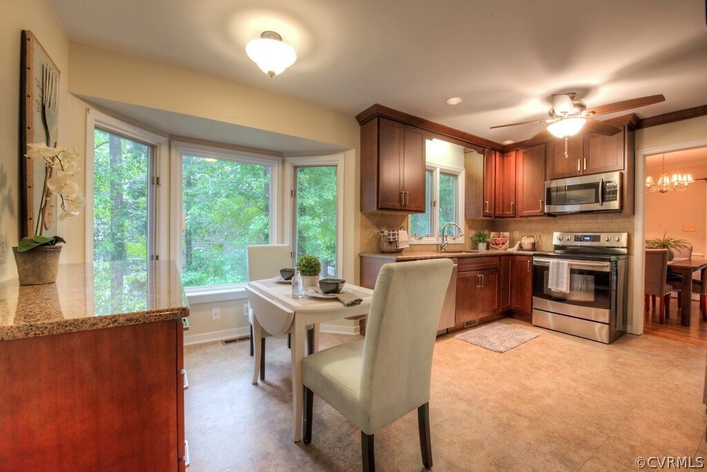 14208 Spring Gate Road Midlothian, VA 23112 - Photo 13 of 44 a kitchen with stainless steel appliances kitchen island granite countertop a stove a sink a refrigerator dining table and chairs