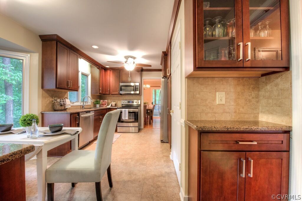 14208 Spring Gate Road Midlothian, VA 23112 - Photo 14 of 44 a kitchen with stainless steel appliances granite countertop wooden cabinets a dining table and chairs