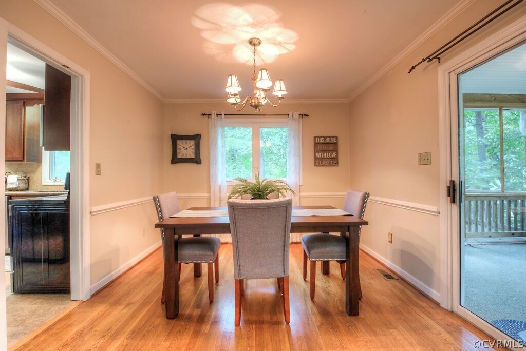 14208 Spring Gate Road Midlothian, VA 23112 - Photo 15 of 44 a view of a dining room with furniture a chandelier and wooden floor