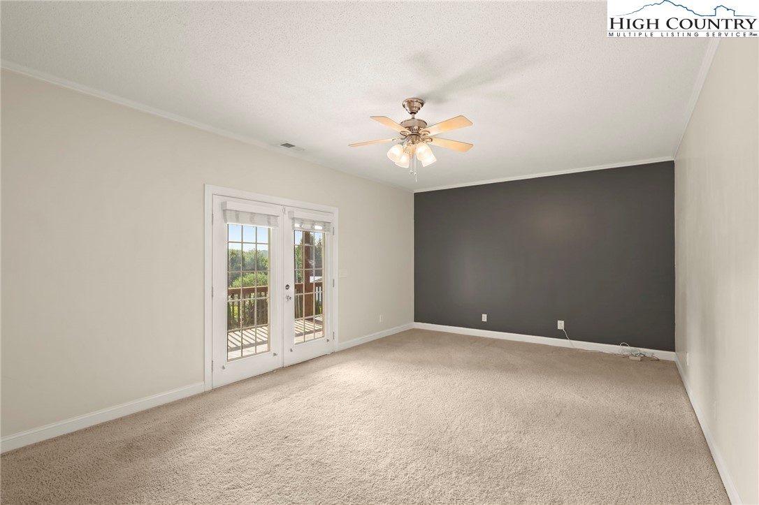 112 Rolling Hill Drive Boone, NC 28607 - Photo 22 of 31 an empty room with windows and chandelier fan