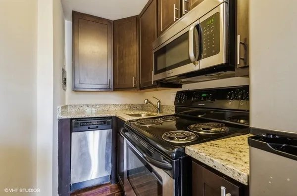 a kitchen with stainless steel appliances granite countertop a stove and a microwave
