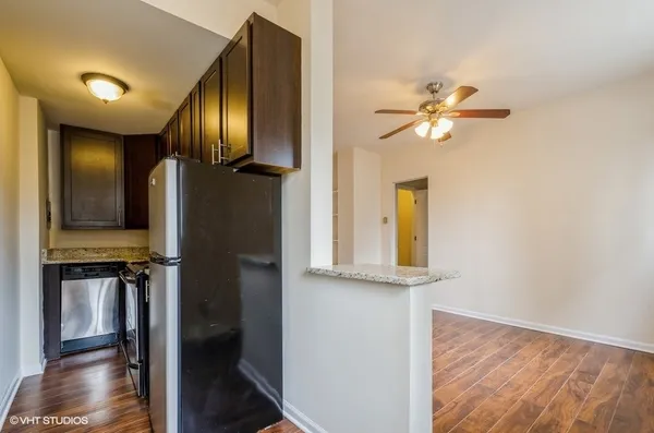a view of a hallway with entryway wooden floor and cabinet