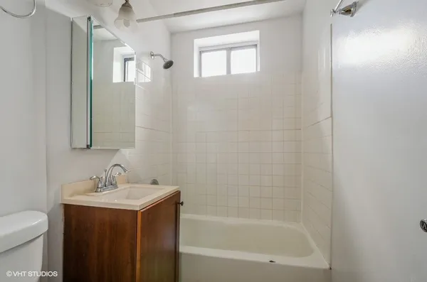 a bathroom with a sink mirror vanity and toilet