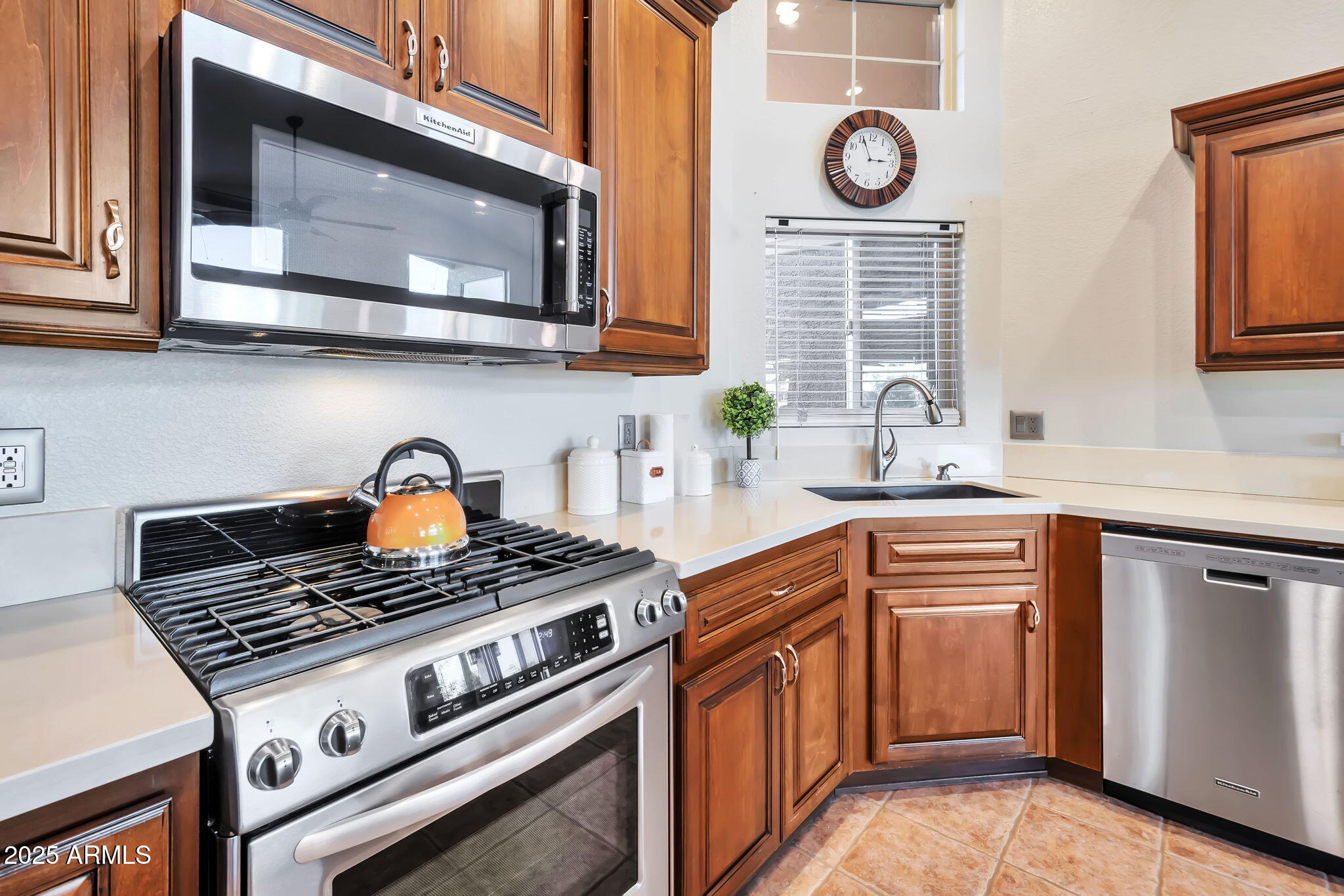15460 West Merrell Street Goodyear, AZ 85395 - Photo 11 of 30 a kitchen with stainless steel appliances granite countertop a stove a sink and a microwave