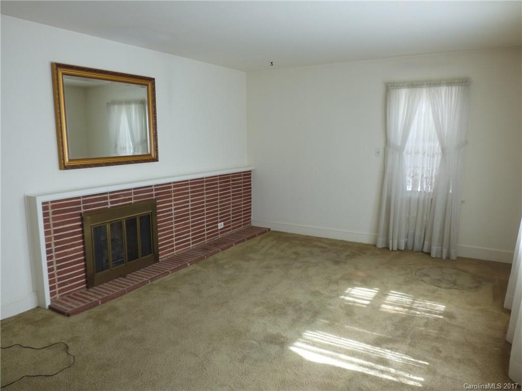 5229 Manning Road Charlotte, NC 28269 - Photo 7 of 18 a view of an empty room with a fireplace and a window