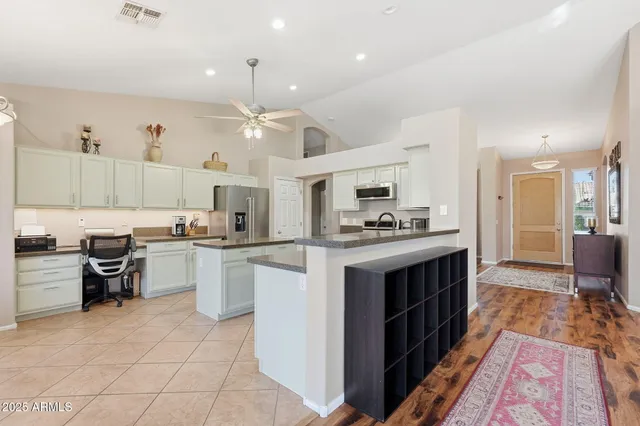 a kitchen with granite countertop a sink and white cabinets