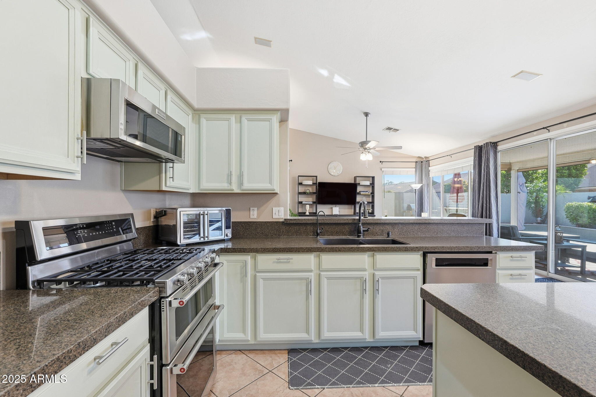 7137 East Laguna Azul Avenue Mesa, AZ 85209 - Photo 17 of 58 a kitchen with stainless steel appliances granite countertop a sink stove microwave and cabinets