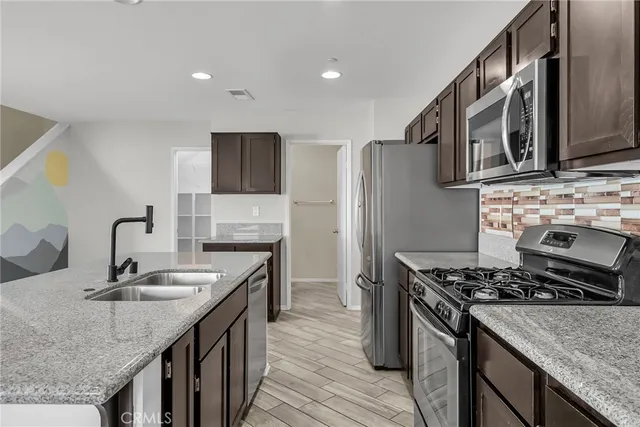 a kitchen with stainless steel appliances granite countertop a sink stove and refrigerator
