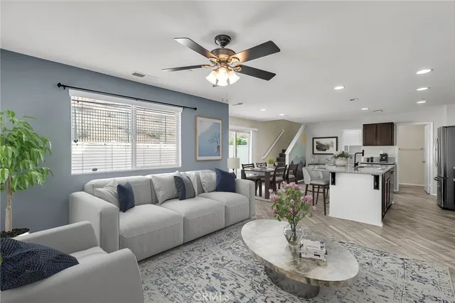 a living room with furniture kitchen view and a large window