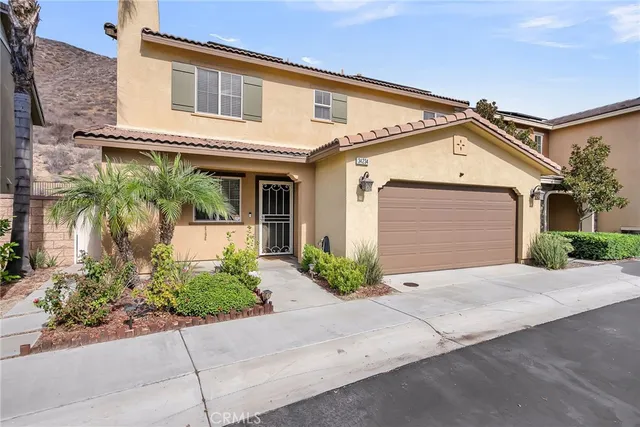 a front view of a house with a yard and potted plants