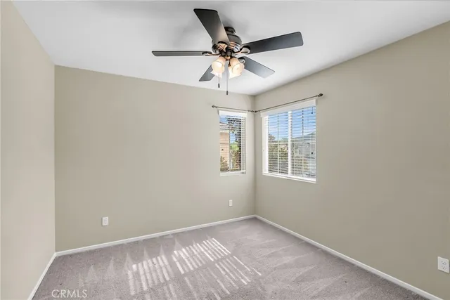 an empty room with a window and a fan