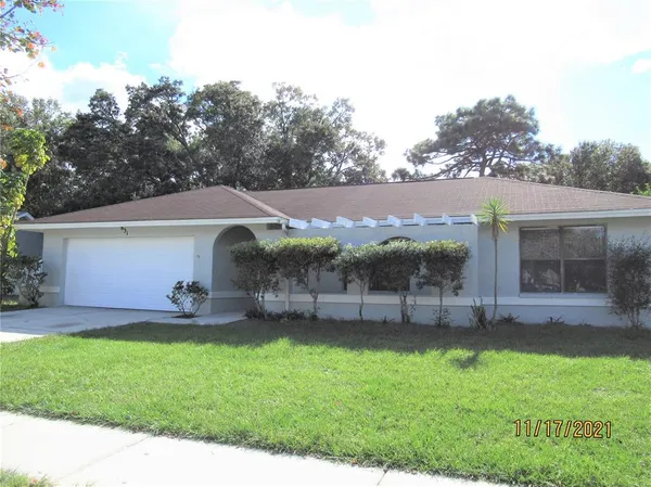 a view of a house with a yard and sitting area