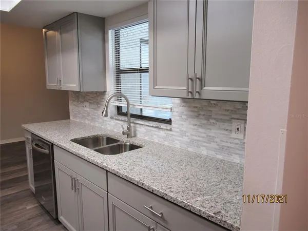 a kitchen with granite countertop a sink and cabinets