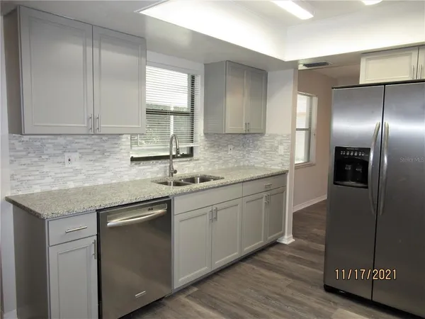 a kitchen with stainless steel appliances granite countertop a sink and a refrigerator