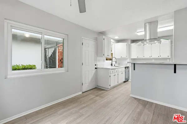a kitchen with a sink cabinets stainless steel appliances and a window