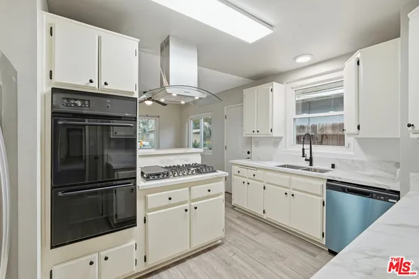 a kitchen with cabinets stainless steel appliances and sink