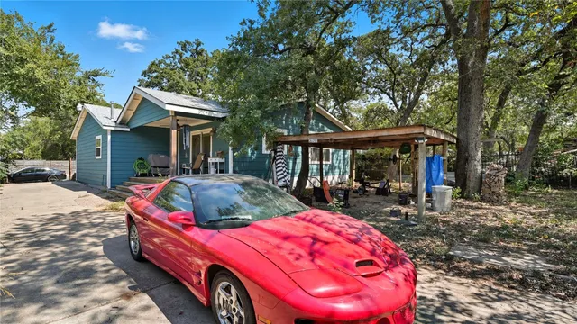 a backyard of a house with a swing table and chairs